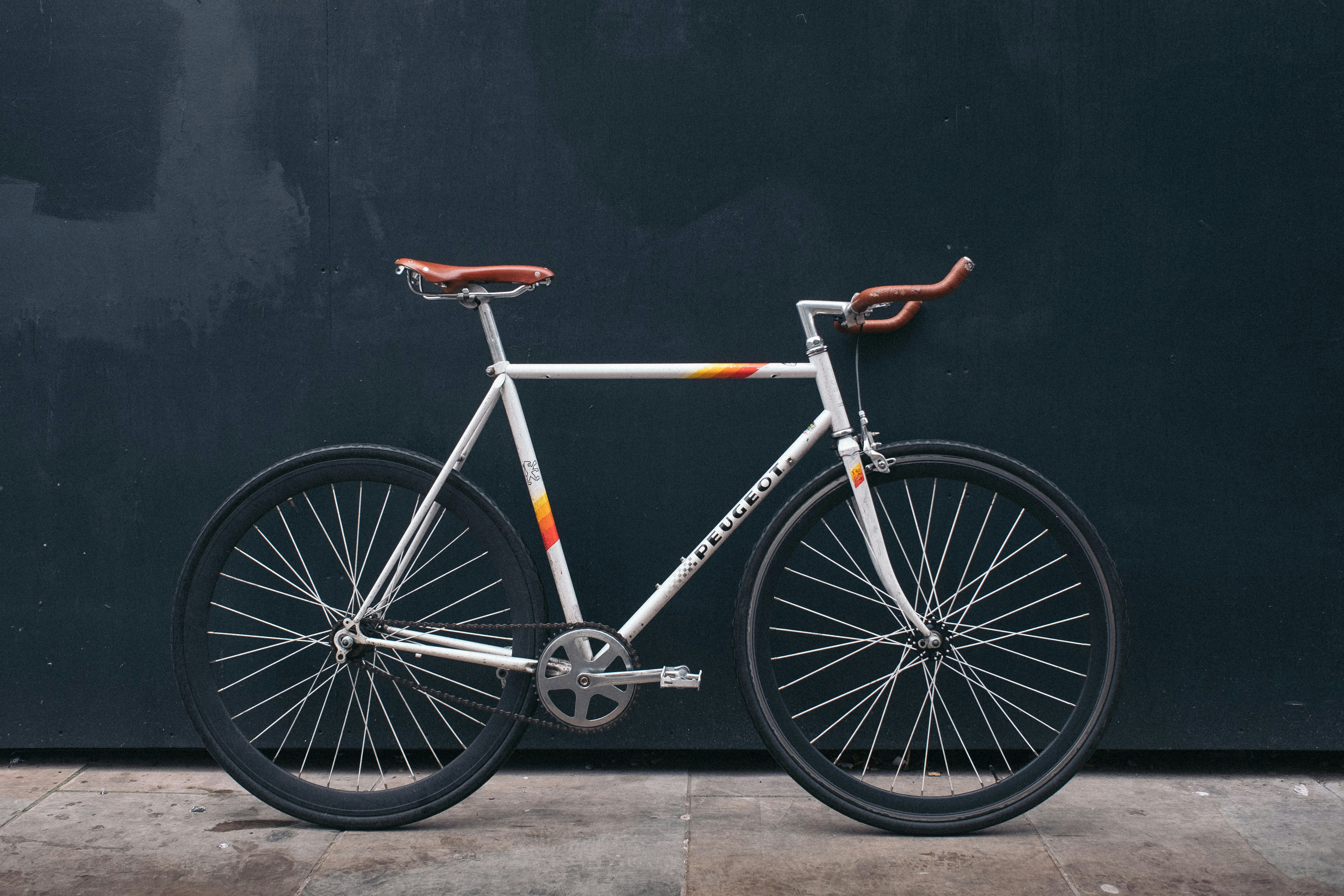 A bicycle leaning on a dark wall.